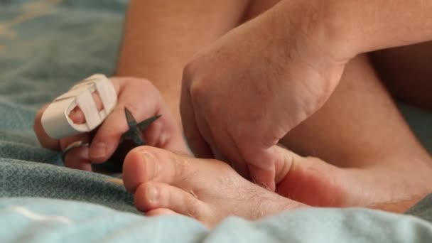 Homem Corta Unhas Dos Pés Com Dedo Quebrado Cama Casa — Vídeo de Stock