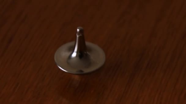 Ein Kleiner Metallgrauer Kreisel Dreht Sich Auf Dem Tisch — Stockvideo