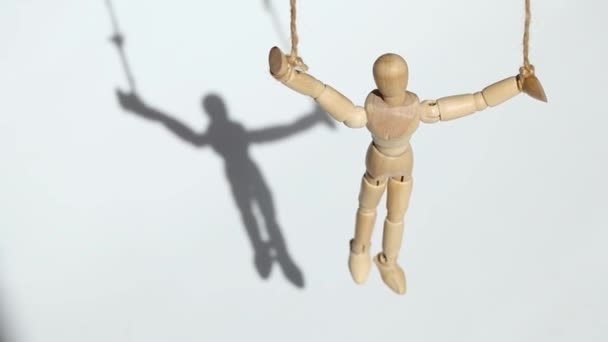 ロープの上の人形は白い背景とそこからの影 人形と人々を制御する — ストック動画