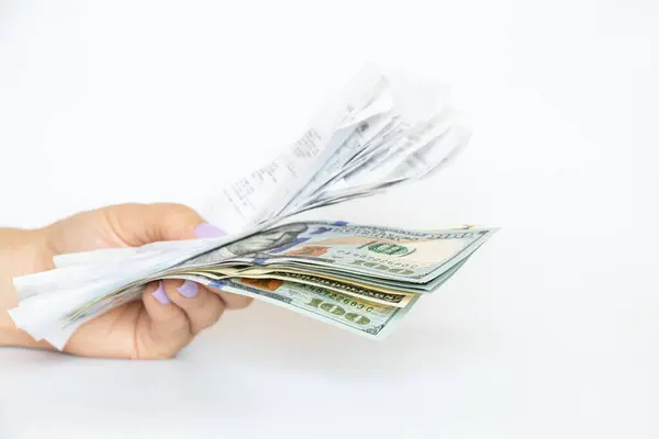 stock image In the hands of a girl are receipts from a grocery store and dollars on a white background, a shopping budget, counting receipts