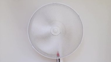 Beyaz kat vantilatörü kapanıyor, dönüyor.