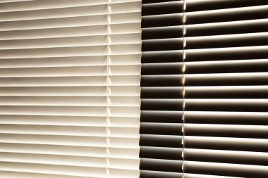 Gün boyunca apartmanın penceresinde beyaz panjurlar var.