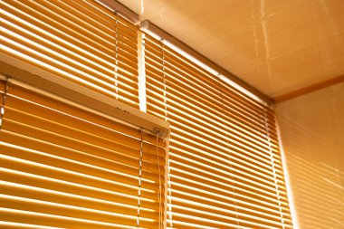 Gündüz vakti apartmanın penceresinde sarı panjurlar var.