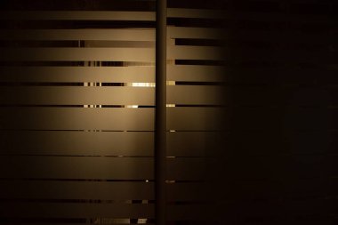 Dairedeki aynalı dolap. Karanlıkta çizgili olan. Arka planda ayna olan dolap.