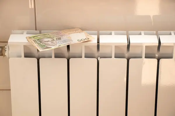 stock image 500 UAH lie on a white radiator in an apartment in Ukraine, the tariff for central heating in the apartment