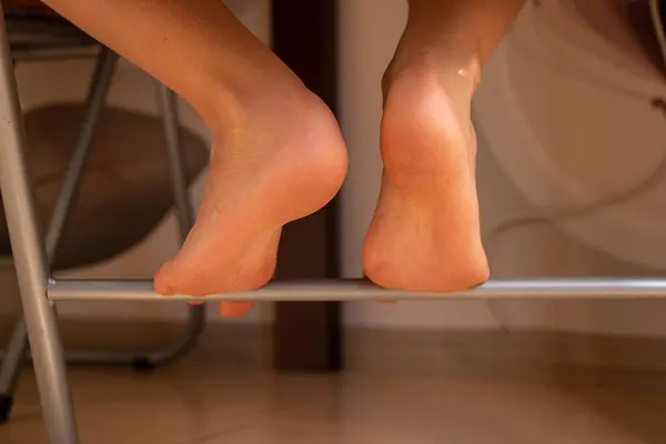 stock image Little boy's bare feet on a chair at home in the kitchen, child's feet