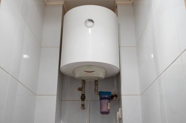 Ukrayna 'daki dairede beyaz su ısıtıcısı tuvalette asılı.