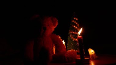 Küçük bir Noel ağacı ve Ukrayna 'da ışıksız bir masada mumları olan bir oyuncak ayı.