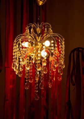 Kırmızı odada eski bir avize yaklaştı. Eski bir avize.