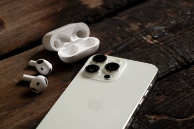 Ukrayna Dnipro 24 Ocak 2025 - Apple iPhone 15 Pro Max White ve Apple Air Pods 4 'ün kulaklıkları masada