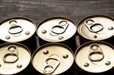 Ahşap bir masada altı teneke kutu, teneke kutularda yemek.