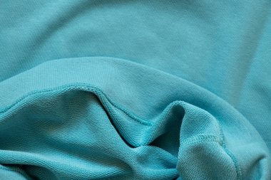 Arka plan olarak sade mavi pamuk kumaş. Yakın plan, siyah kıyafetler.