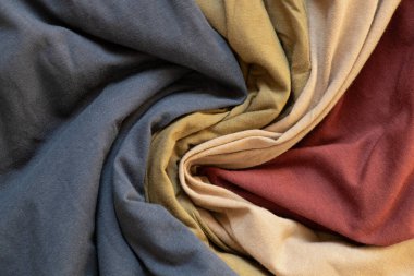 Dört renkli tişört kırmızı, zeytin, bej ve mavi arka plan olarak sarılır, moda kıyafetleri