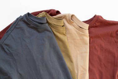 Dört buruşuk pamuklu tişört mavi, bej, zeytin ve kırmızı beyaz arka planda, kıyafetlerde, günlük tişörtlerde