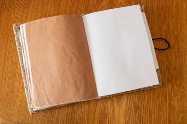 Kağıt ve çuval bezi kaplı boş defter ahşap masa, yaratıcı defter