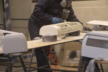 Ressam, atölyedeki boya spreyinden, boyacıdan, boyacıdan ve restorasyondan klimayı boyuyor.