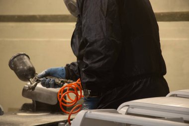 Ressam, atölyedeki boya spreyinden, boyacıdan, boyacıdan ve restorasyondan klimayı boyuyor.