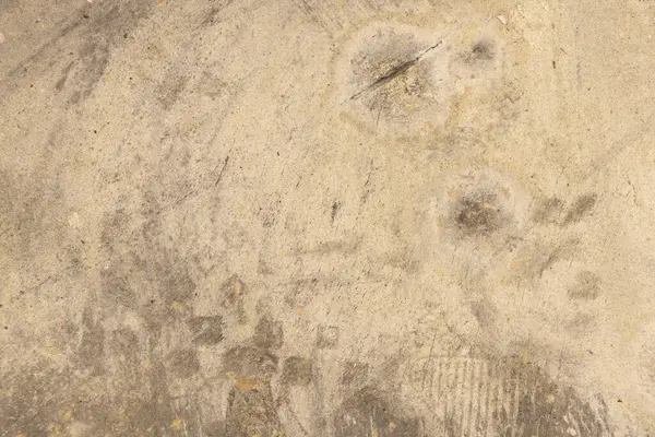 Atölyede lekeler ve lekeler olan gri beton zemin, arka planda beton zemin.