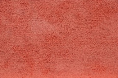 Mercan renkli vakanın kabarık yumuşak yüzeyi arka planda yakın plan görüntüsü olarak.