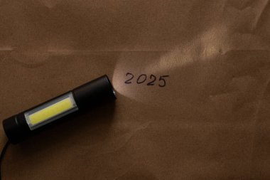 Cep portatif siyah el feneri, üzerinde LED ampuller, karanlıkta kahverengi kağıt, fener.