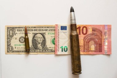 Büyük bir fişek bir avronun üzerinde ve küçük bir fişek de beyaz arka planda, yardımın büyüklüğünde bir doların üzerinde duruyor.