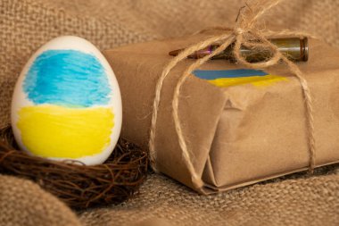 Ukrayna bayraklı Paskalya yumurtası ve bayrağı olan bir paket, bayramlarda Ukrayna 'ya destek, Paskalya, insani yardım
