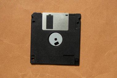 Kahverengi kağıt üzerinde eski siyah disket, yakın plan, eski teknoloji