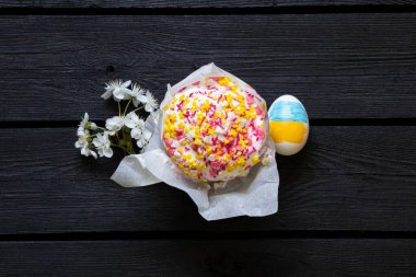 Ukrayna bayrağı boyanmış Paskalya yumurtası, kulich ve çiçek açan kiraz dalı siyah ahşap masa üzerinde, Paskalya Bayramı Ukrayna 'da.