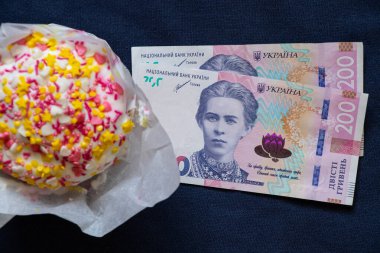 Paskalya pastası ve 200 Hryvnia faturası mavi arka planda, Paskalya harcamaları, harcamalar ve para