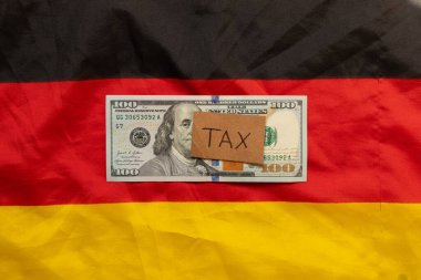Dolar tasarısı ve Almanya bayrağının arka planına karşı yazıt vergisi, vergileri ve ekonomiyi sembolize ediyor