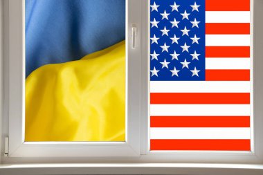 Arkasında ABD ve Ukrayna 'nın bayrakları olan pencere, ortak bir geleceğe bakan iki ülkenin dostluğu ve birliğinin bir metaforu olarak.