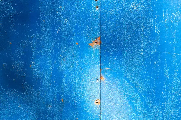 Arka plan olarak demir kapılardaki mavi boya çatlaklarla kaplı eski mavi boya.