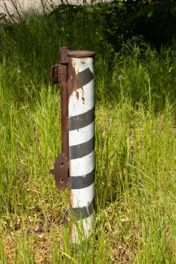 Ukrayna 'da orman yolu yakınında çizgili metal kazık.