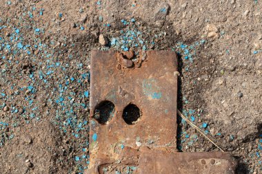 Asfalttaki paslı plaka, bağlanan parça, asfaltta paslı metal.