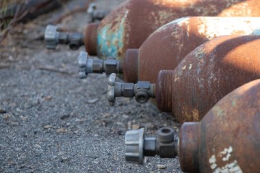 Eski paslı silindirler Ukrayna 'da güneşin altında asfaltta yatıyor.