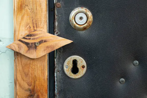 Köyde anahtar delikleri olan eski bir kapı. Siyah yumuşak döşemeleri var.