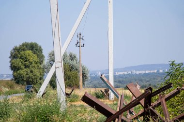 Yol, kablolu direkler ve şehrin arka planına karşı yol kenarında kirpiler, Ukrayna 'da savaş, şehrin savunması.