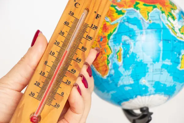 Bir kadının elindeki termometre, arka plan, iklim değişikliği ve küresel ısınmaya karşı.