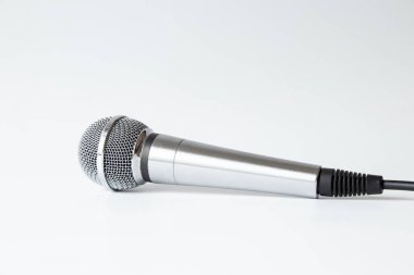 Beyaz arka planda kablolu profesyonel gümüş mikrofon, ses kaydı için stüdyo ekipmanı