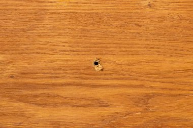 Ahşap yüzeyde delik, mobilya tamir teması için arka plan, tahtanın ortasında delik.