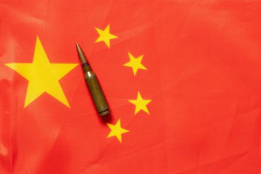 Çin bayrağı, yakın plan bir mermiyle, savaş sembolü, silahlar ve jeopolitik gerilime karşı saldırganlık