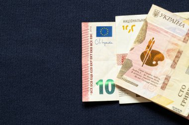 Mavi arka planda on avro ve yüz hryvnia, destek, ticaret ve mali yardım, iş ve finans kavramı
