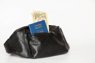 Ukrayna pasaportu ve 500 Hryvnia banknotu beyaz bir arka planda bel çantasında, belgeler ve para