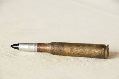 Hafif kumaş üzerine tek büyük kalibreli kartuş, askeri temalı.