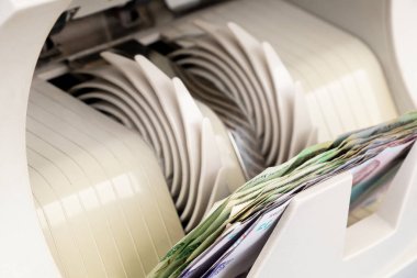 Bir paket Ukrayna hryvniası ile para sayma makinesi, banknotları sayma süreci, sayma makinesi