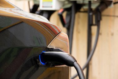 Ukrayna Dnipro 05 / 28 / 2025 - Tesla elektrikli otomobili şarj sırasında bir elektrik dolum istasyonunda hızlı şarj kablosuna bağlandı