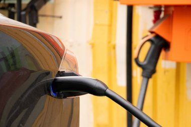 Ukrayna Dnipro 05 / 28 / 2025 - Tesla elektrikli otomobili şarj sırasında bir elektrik dolum istasyonunda hızlı şarj kablosuna bağlandı