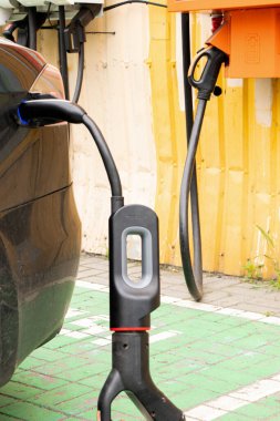Ukrayna Dnipro 05 / 28 / 2025 - Tesla elektrikli otomobili şarj sırasında bir elektrik dolum istasyonunda hızlı şarj kablosuna bağlandı
