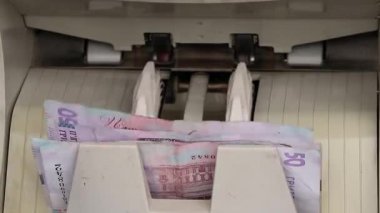 Bir paket Ukrayna hryvniası ile para sayma makinesi, banknotları sayma süreci, sayma makinesi