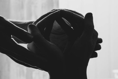 Karanlığın içinde alçıdan yapılmış elleri tutan kadın eller, alçıdan yapılmış eller.